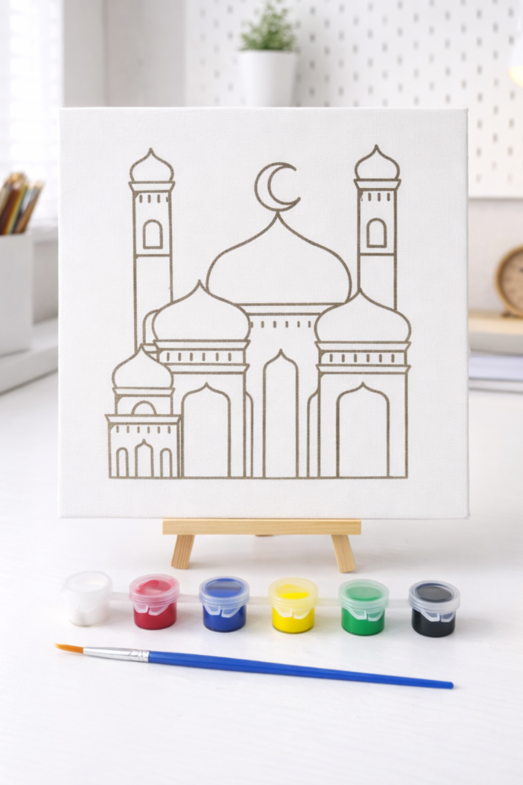 Artistic drawing of a mosque on a white board with coloring supplies on a desk.